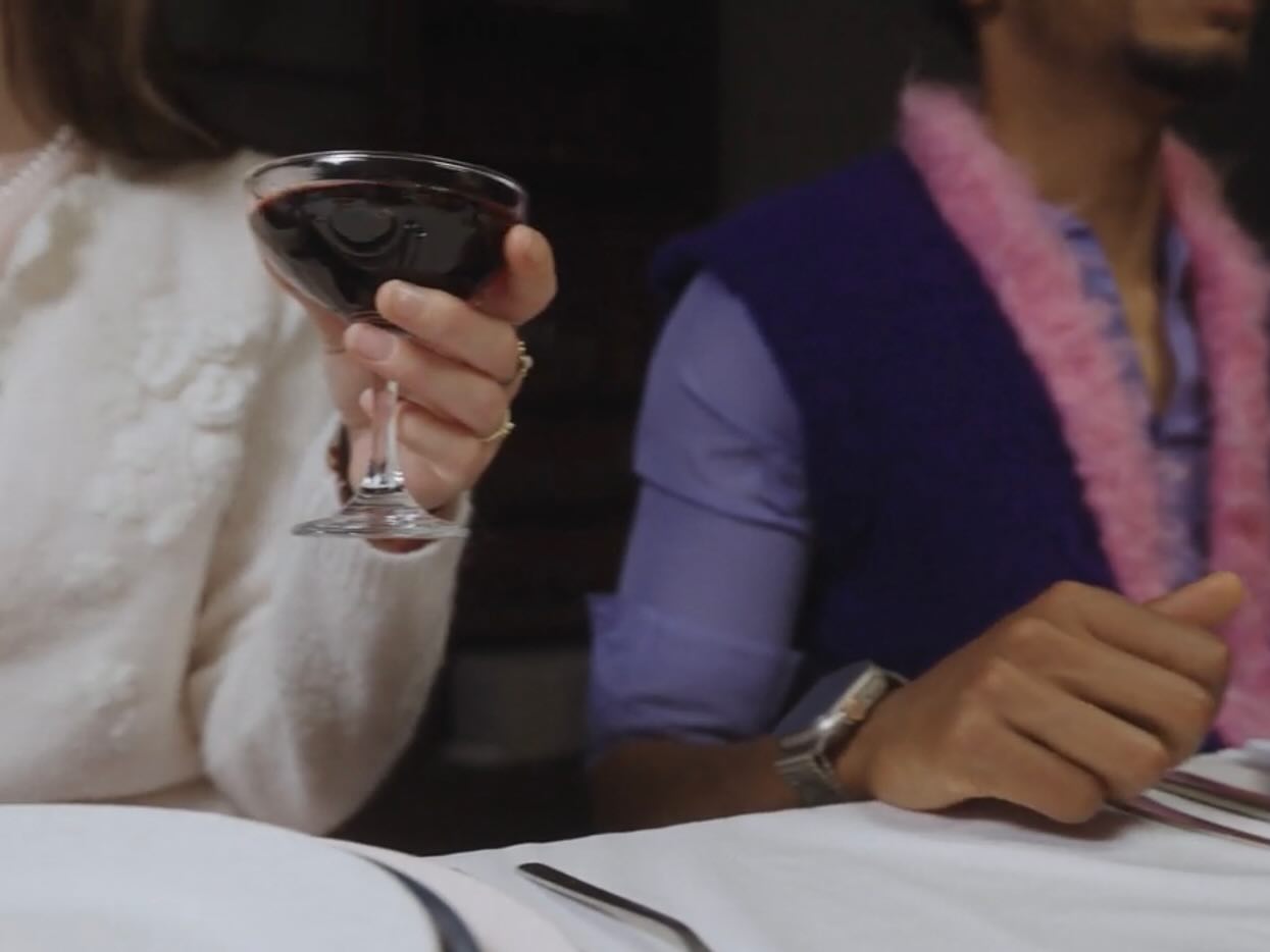 Film still: guests at the table mid-toast